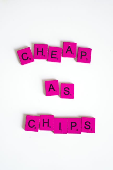 Image of pink Scrabble tiles arranged to spell the words 'CHEAPS' at the top, 'AS' in the middle, and 'CHIPS' at the bottom, positioned on a plain white background. The tiles are rectangular with a matte finish, black letter characters, and small numerical values in the bottom right corner. The arrangement is slightly staggered and creates a clean, minimalistic visual focus. This simple composition emphasizes the playful yet organized nature of word-based objects, subtly connecting to themes of waste or rubbish collection through the idea of sorting or categorizing items, as might be seen in independent waste handling or rubbish removal services provided by companies like Rubbish Clearance Brentford. The overall scene is evenly lit and free of distractions, highlighting the clarity of the message conveyed through the tiles' arrangement and text.